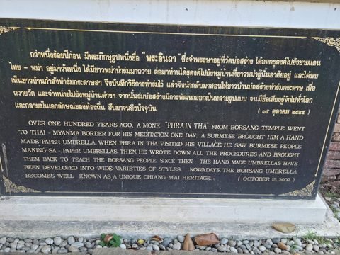Une plaque de pierre noire aux lettres dorées, en thaï et en anglais, qui raconte la légende du moine Phra In Tha