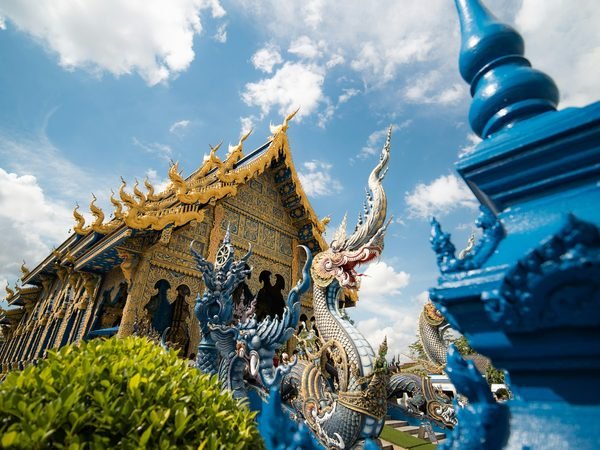 The cobalt and gold facade of Wat Rong Suea Ten, the Blue Temple, and its naga balustrade