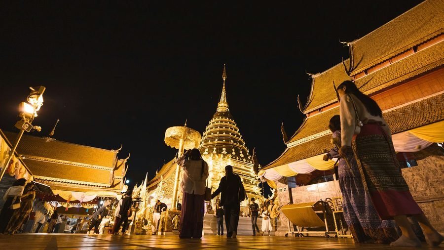 Visitors on the upper terrace of Wat Phra That Doi Suthep after dark, around the gilded chedi