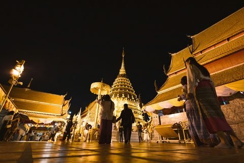 Visitors on the upper terrace of Wat Phra That Doi Suthep after dark, around the gilded chedi