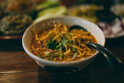 A bowl of khao soi with coriander and crisp noodles on top