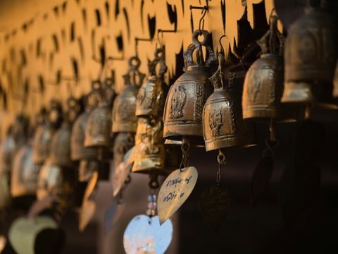 A row of bronze temple bells hung with votive plaques