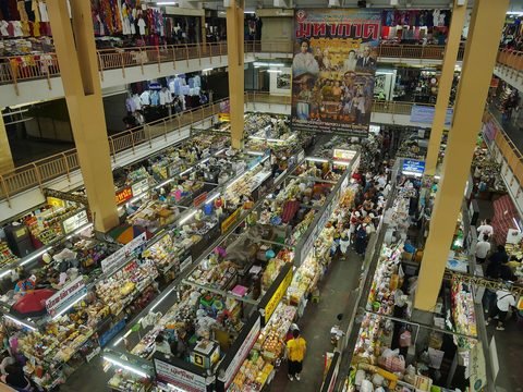 The atrium of Warorot Market from an upper gallery, with food stalls below and clothing along the balconies