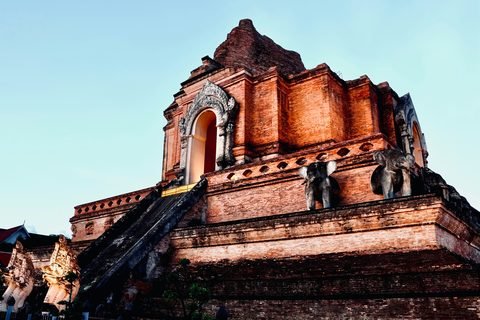 The weathered brick flank of Wat Chedi Luang's chedi against a clear sky
