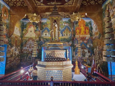 Inside the city pillar shrine: a tiered gilded and mirrored structure topped by a small standing figure, surrounded by painted walls