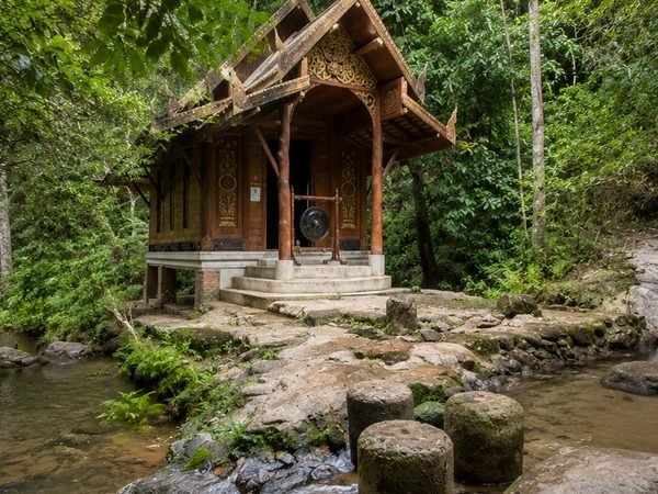 The small hall of Wat Khantha Phueksa under the trees, in the stream that runs through the village