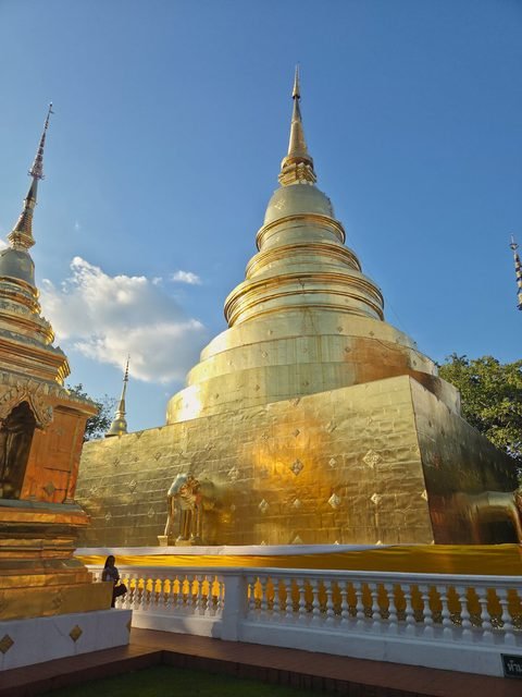 The gilded chedi in late-afternoon sun, its bell-shaped body rising from a square base